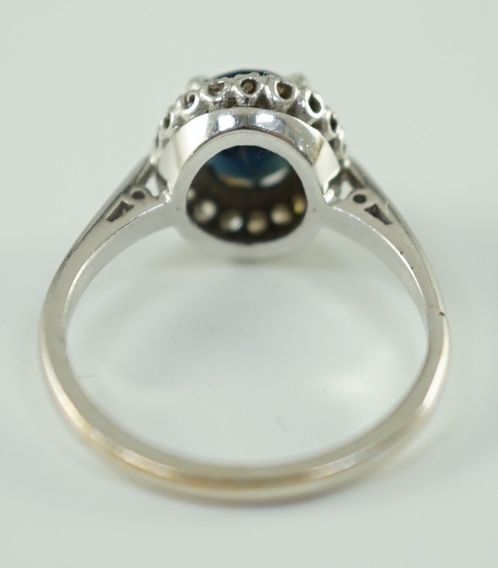 An 18ct white gold, sapphire and diamond set oval cluster ring